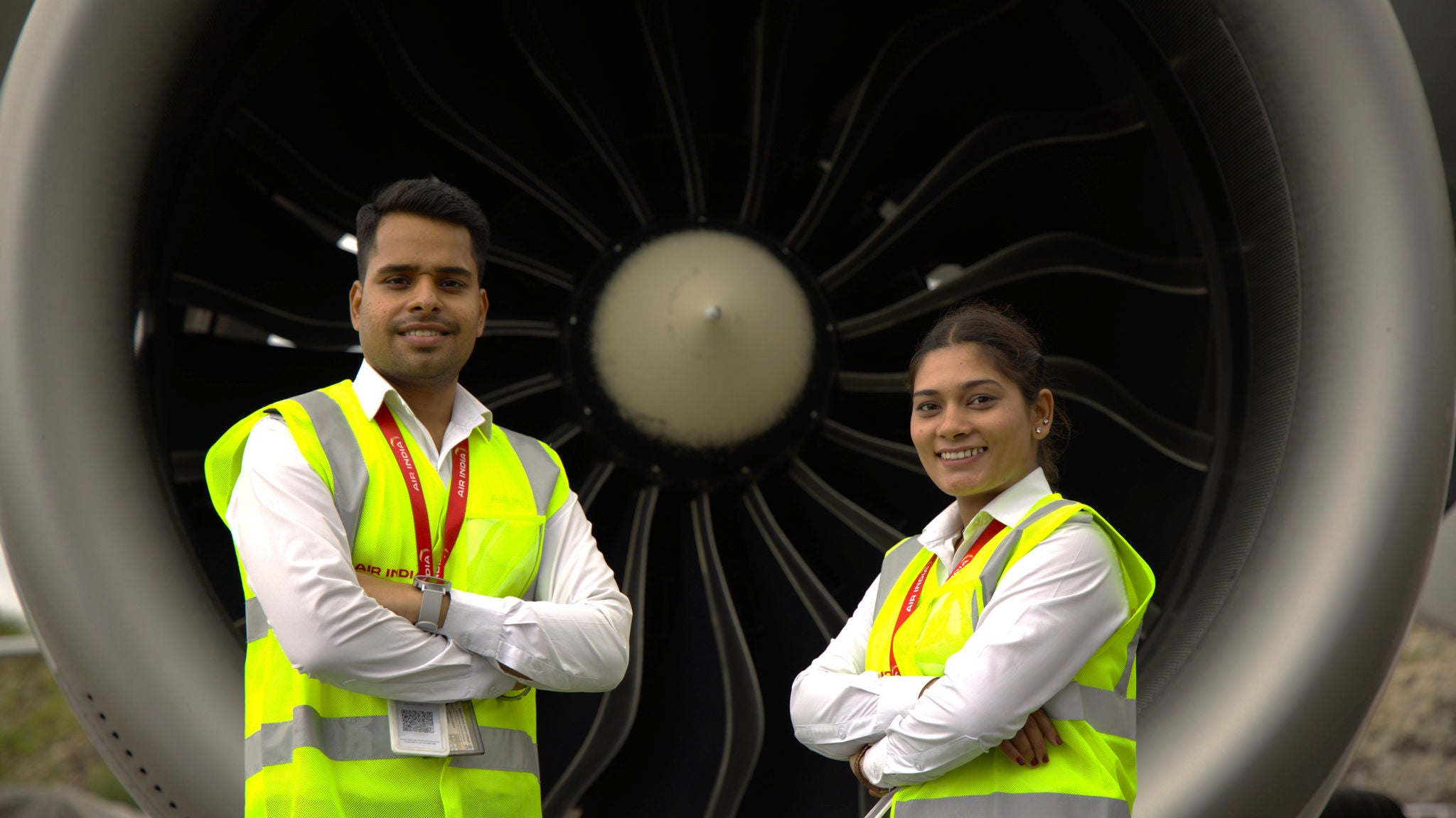 Air India engineers pose in front of aircraft engine